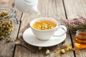 Healthy chamomile tea poured into white cup - Chamomile Tea Benefits