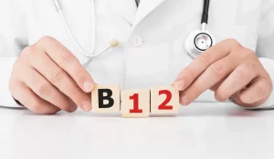 Doctor holds wooden cubes in his hands with text B12 - Vitamin B-12 benefits