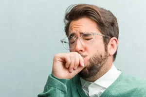 entrepreneur man face closeup with a sore throat - phlegm causes