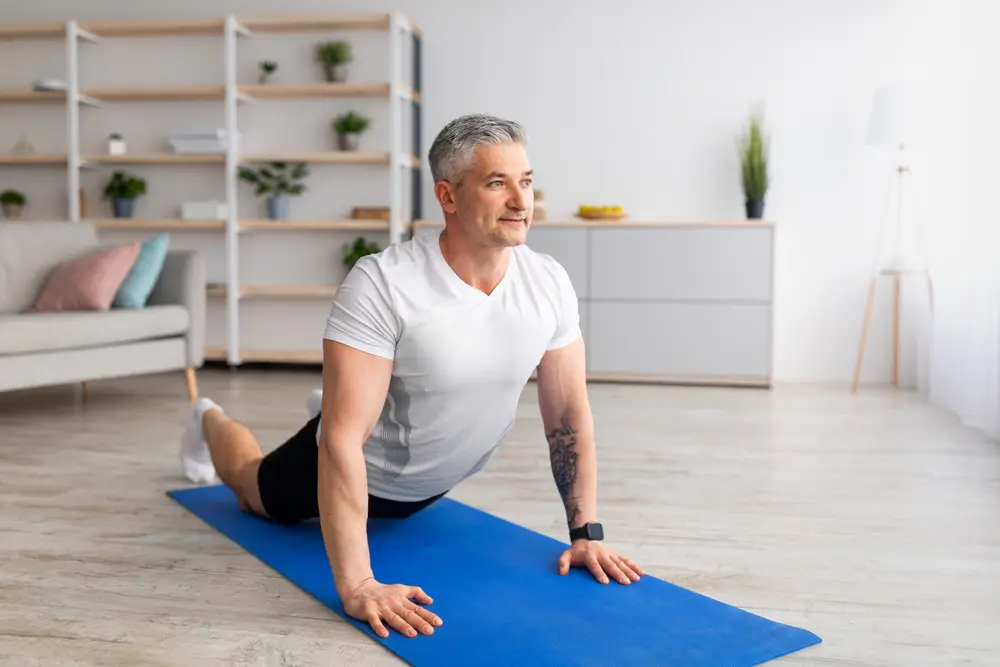 Relief lower back pain. Mature man doing sphinx cobra pose